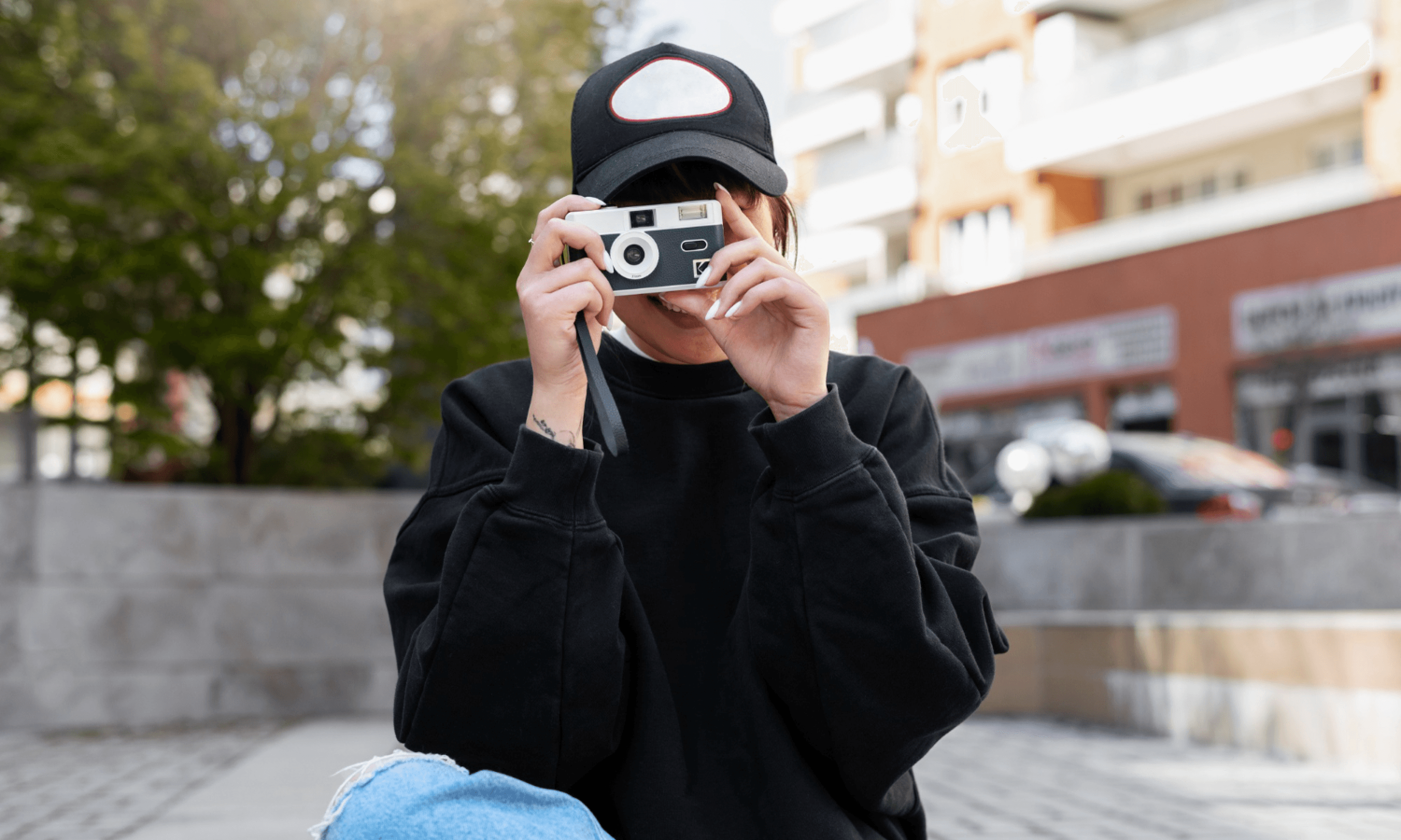 a woman holding a digital camera and taking a photo