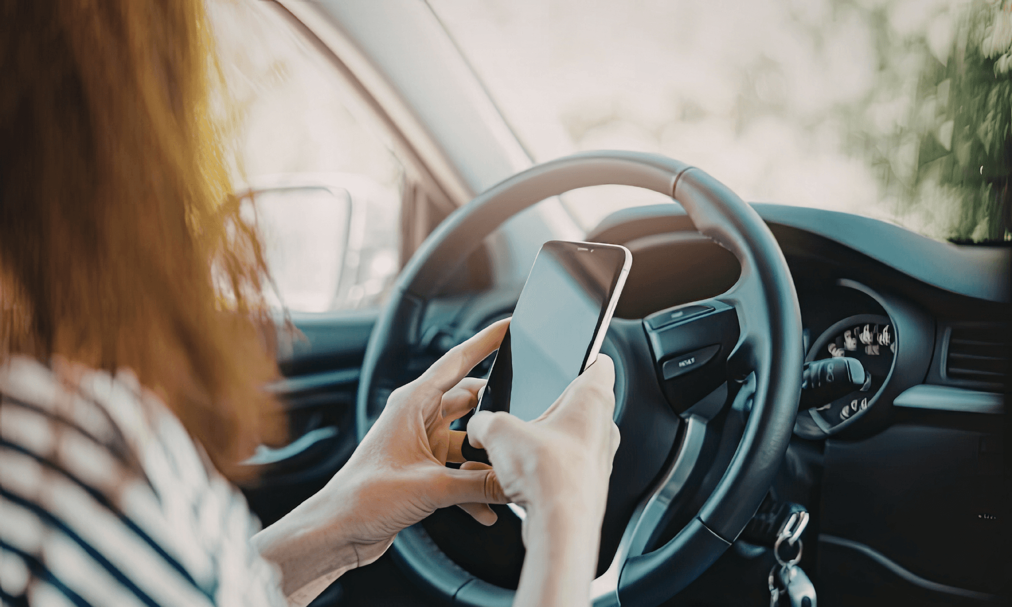 A female driver using a mobile phone while securely parked.