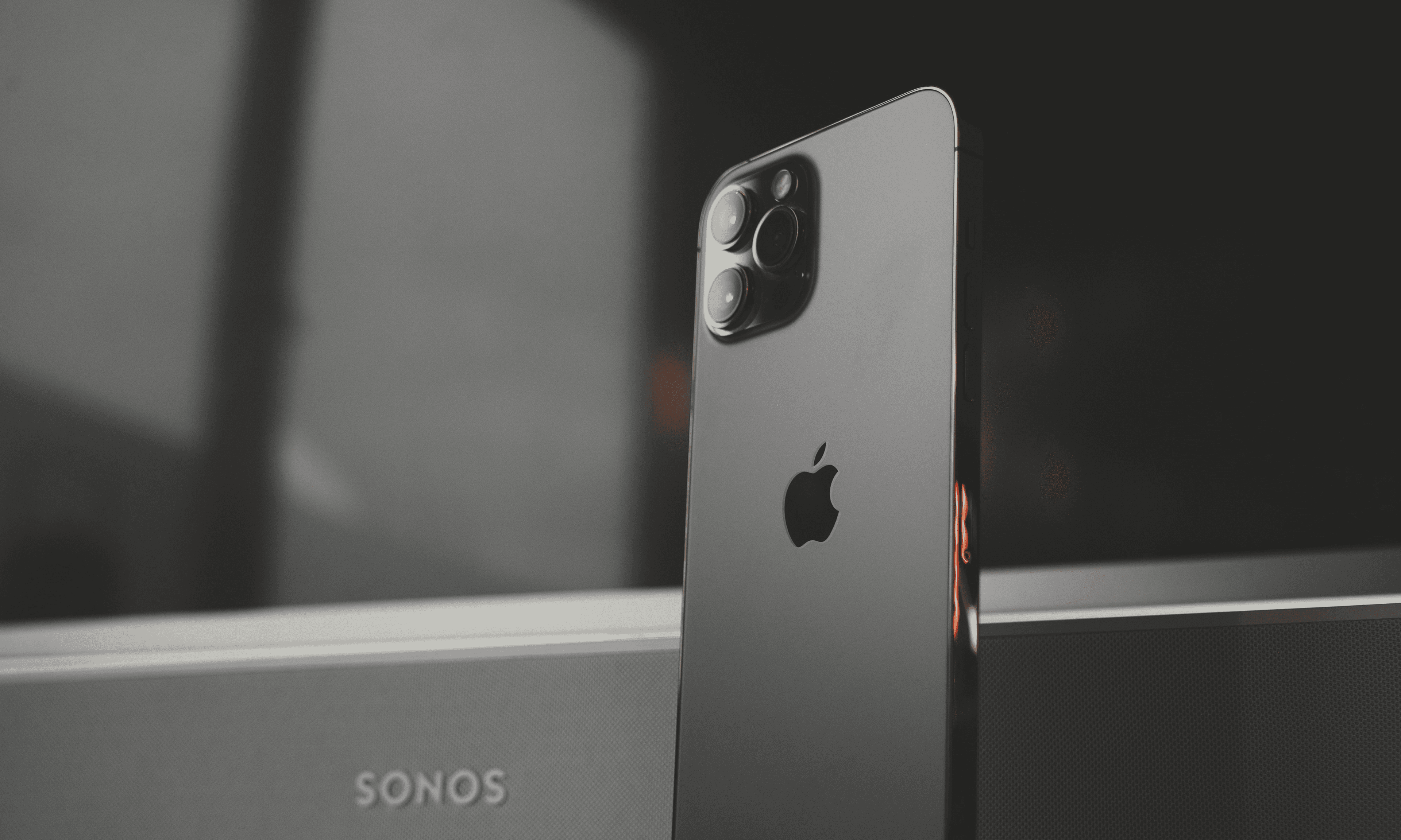 upright standing iphone in grey colour next to a smartspeaker